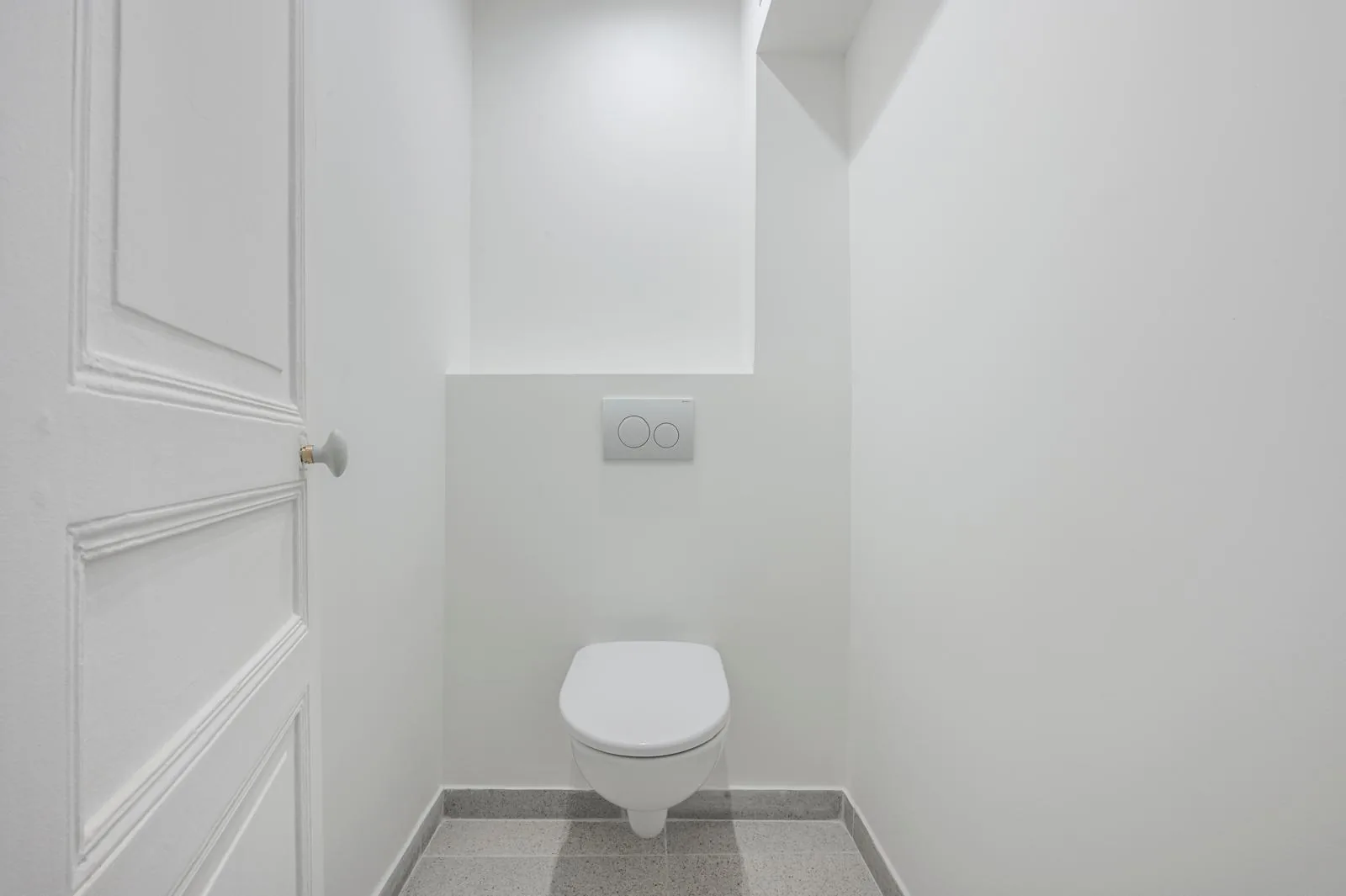 Le même WC après rénovation par CK Bâtiment : cuvette suspendue, coffrage droit et sol en terrazzo