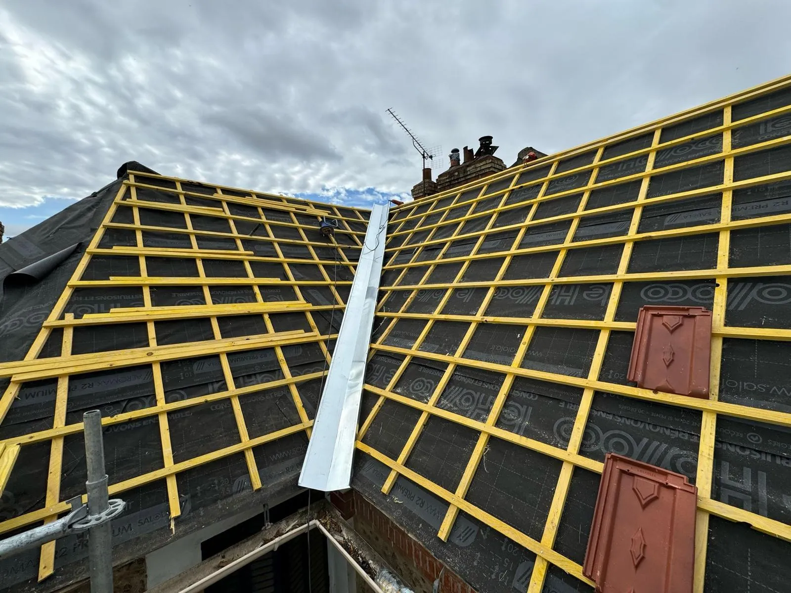 Chantier de rénovation extérieure CK Bâtiment : échafaudage et écran de sous-toiture sur un pignon